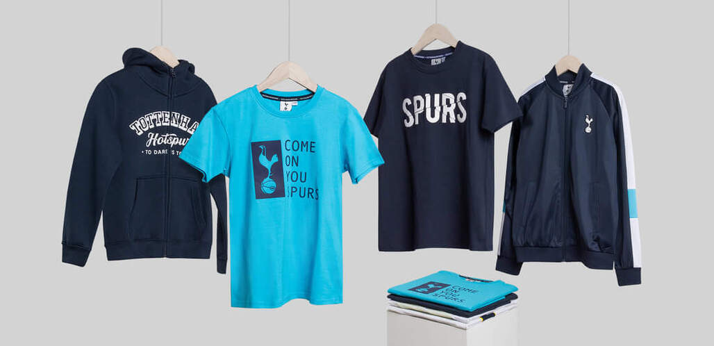 A selection of blue tottenham hotspur garments hung from hangers on wire