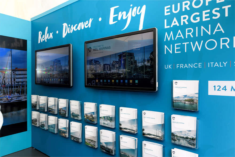 A TV on the wall of MDL marina's exhibition stand at Southampton Boat Show