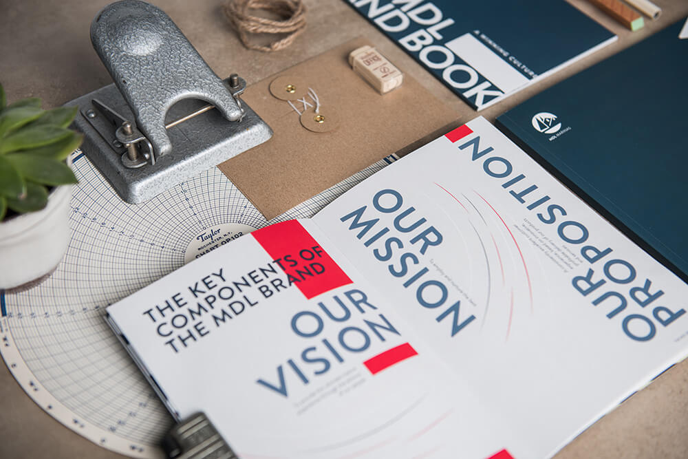 Styled photograph of MDL Marinas branded books and stationary