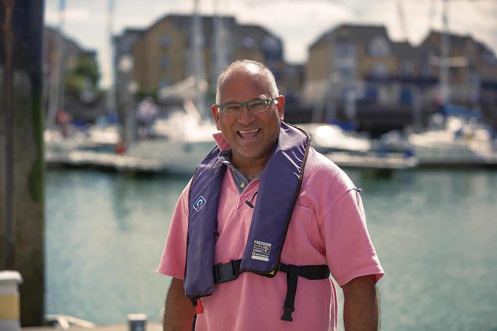 A man in a pink shirt standing in front of the water at an MDL marina in Southampton
